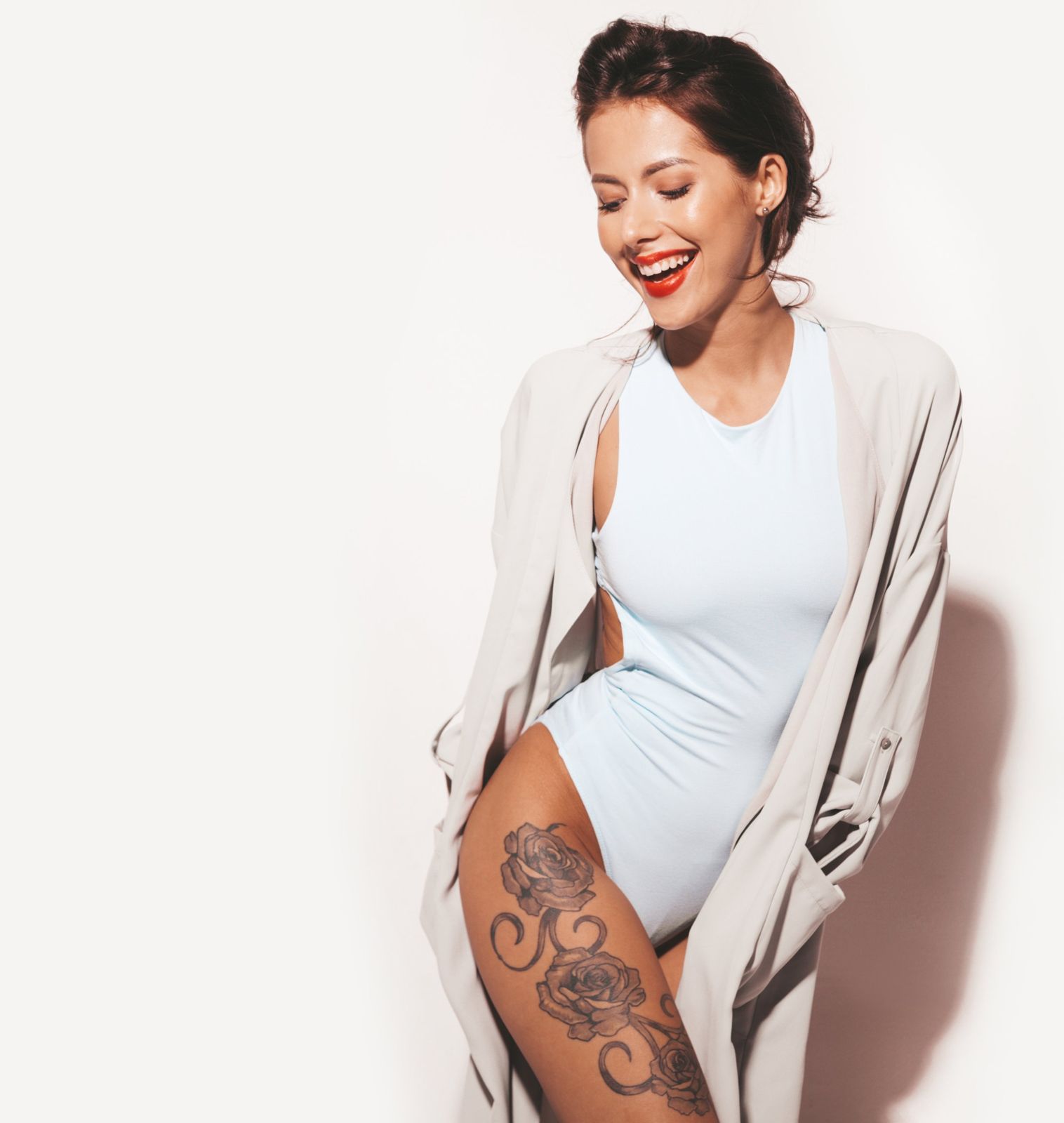 Tatouage de roses sur la cuisse d'une femme souriante